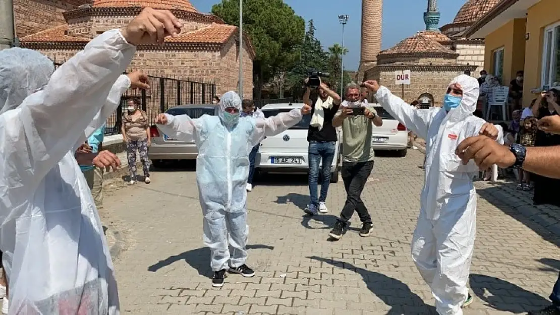 Damat düğünde korona virüsten korunmak için özel tulum giyerek göbek attı
