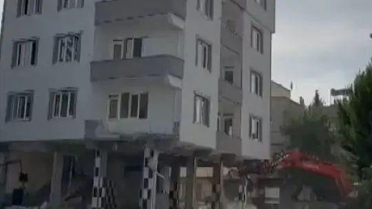 Ağır hasarlı bina yıkım esnasında kepçenin üzerine çöktü