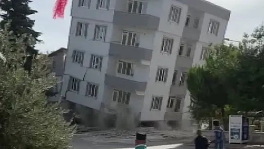 Ağır hasarlı bina yıkım esnasında kepçenin üzerine çöktü