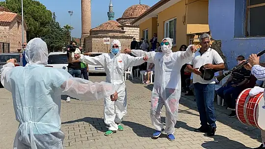 Damat düğünde korona virüsten korunmak için özel tulum giyerek göbek attı