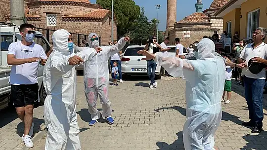 Damat düğünde korona virüsten korunmak için özel tulum giyerek göbek attı