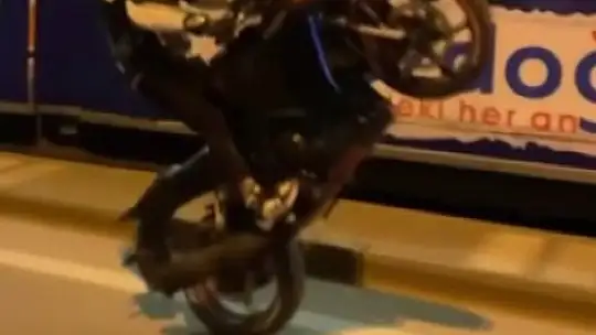 Yoğun trafikte motosikletin önünü kaldırarak akrobatik hareketler yaptı